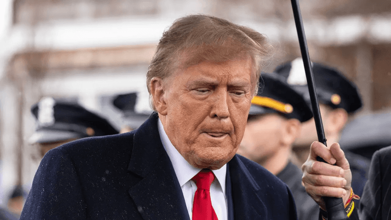 Image of Trump in an outdoor setting with people around.