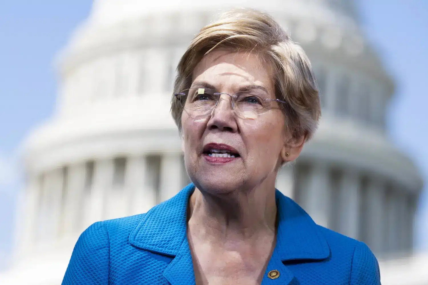 Senator Elizabeth Warren speaking in front of the Capitol building.