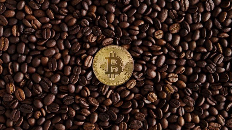A bitcoin token on top of a coffee grains