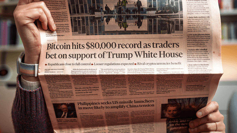 Man reading newspaper with BTC price headline.