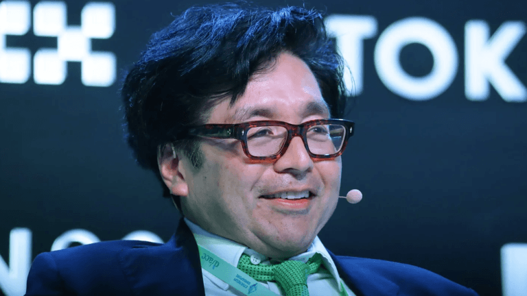 Tom Lee on stage at an event.